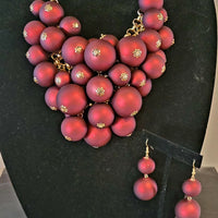 gold tone statement necklace with linked chain, red multi size balls as focal point and matching earrings